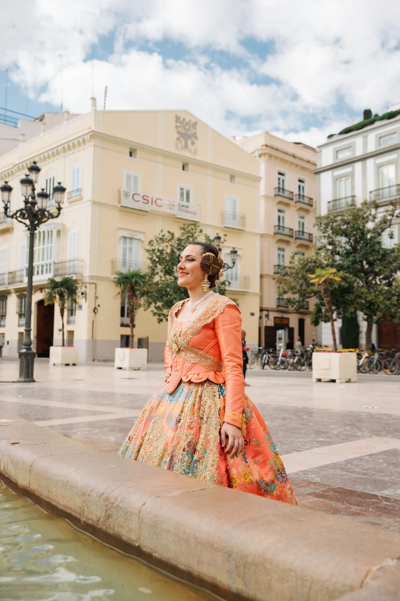 Mujer vestida de fallera mirando a fuente de Valencia - Foto 1