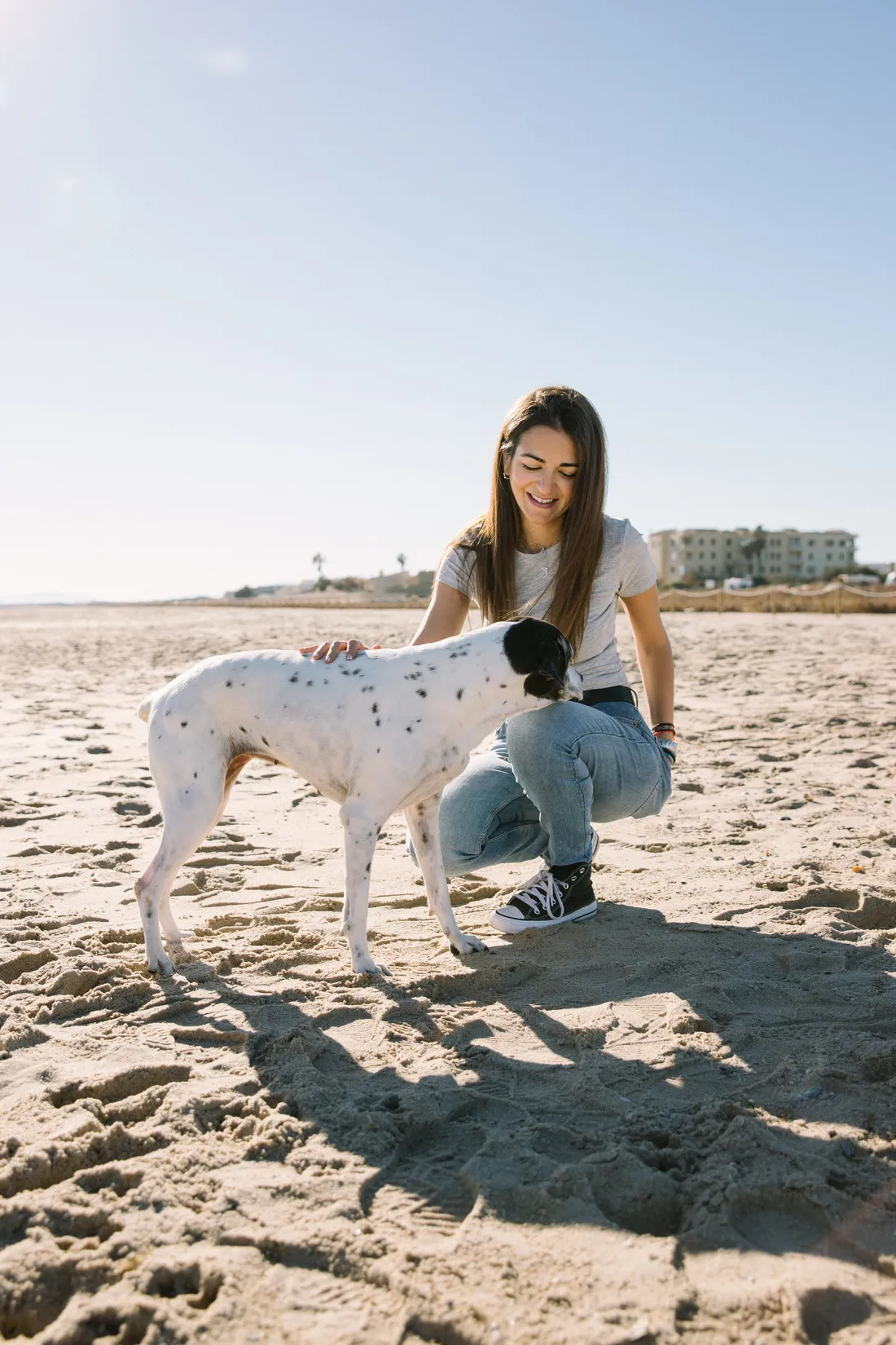 Chica con sus dos perros en la playa disfrutando de un buen momento - Foto 1